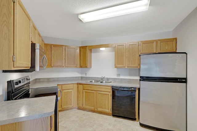 kitchen with a textured ceiling, sink, light brown cabinets, and appliances with stainless steel finishes