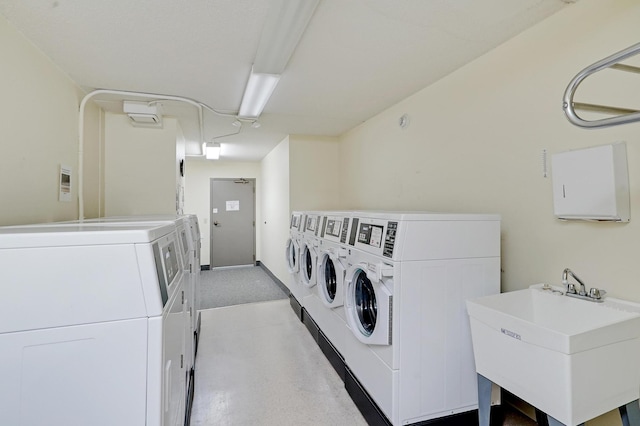 clothes washing area featuring washer and clothes dryer and sink