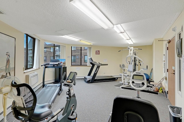 workout room with a textured ceiling, baseboard heating, and a wall mounted air conditioner