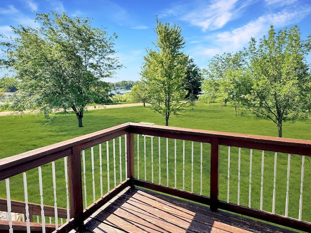 wooden terrace featuring a water view and a yard