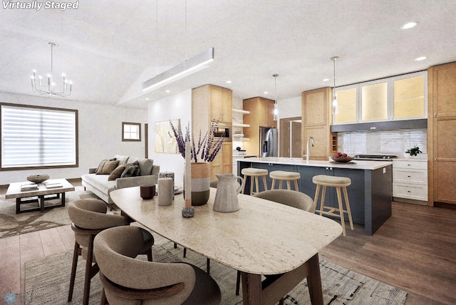 dining space featuring sink, a textured ceiling, hardwood / wood-style floors, and a chandelier