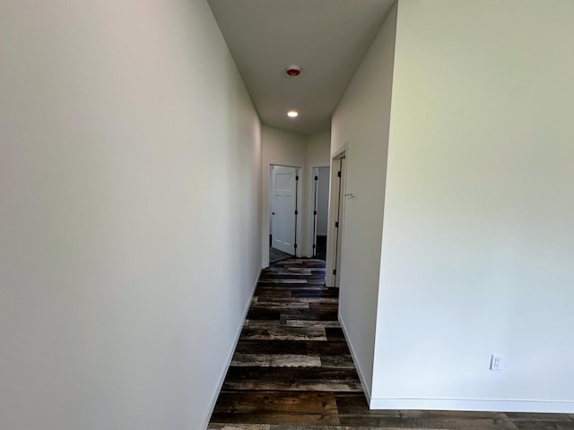 hallway featuring baseboards, dark wood-style floors, and recessed lighting