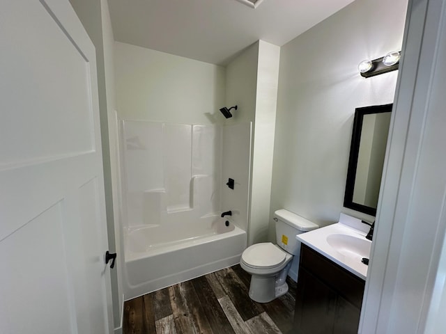 full bath featuring washtub / shower combination, toilet, vanity, and wood finished floors