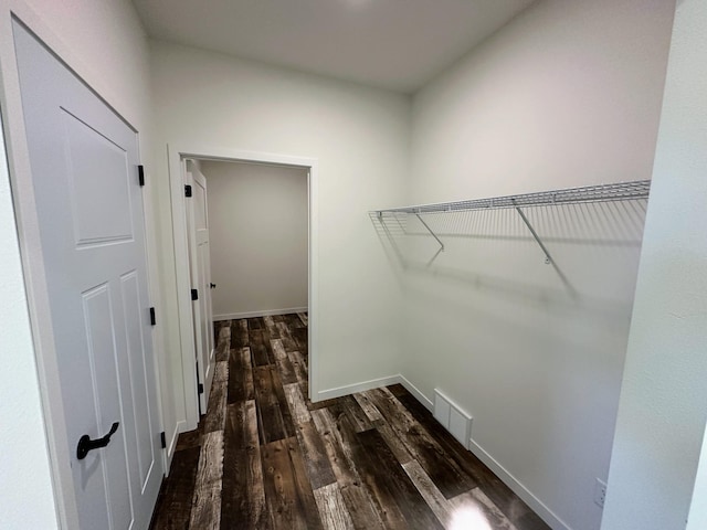 walk in closet with dark hardwood / wood-style floors