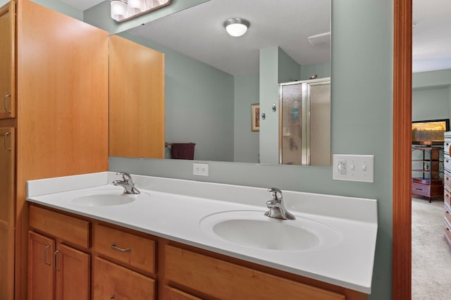 bathroom featuring vanity, a textured ceiling, and a shower with door