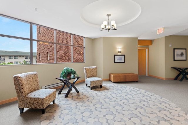 living area featuring a chandelier, a tray ceiling, and carpet flooring