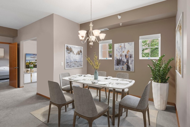 carpeted dining space with a chandelier