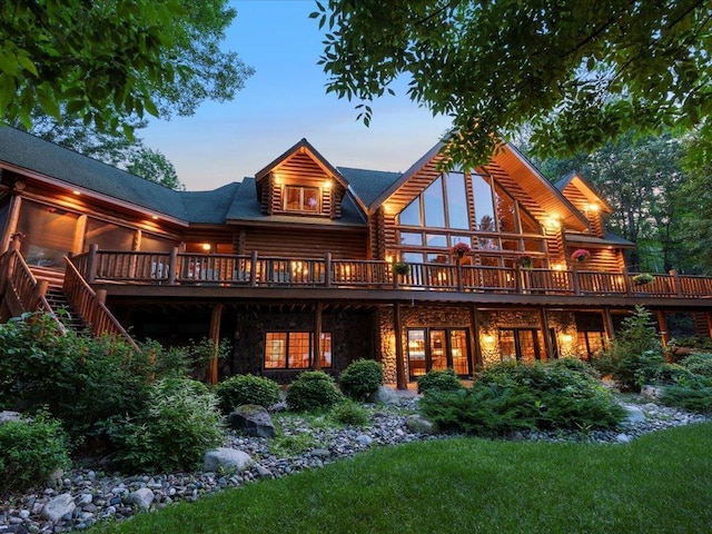 back house at dusk featuring a wooden deck