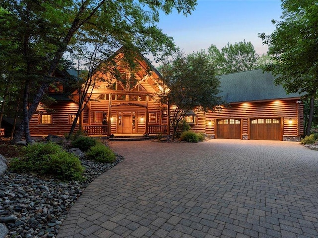 log-style house with a garage and covered porch