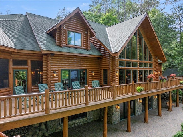 back of house featuring a wooden deck and a patio