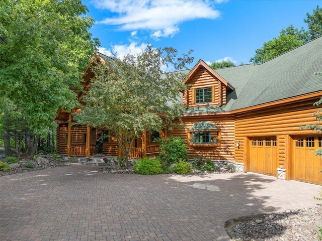 log home with a garage and covered porch