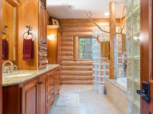 bathroom featuring a relaxing tiled tub, vanity, and rustic walls