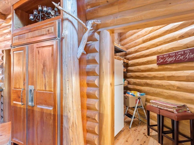 staircase featuring log walls and hardwood / wood-style floors