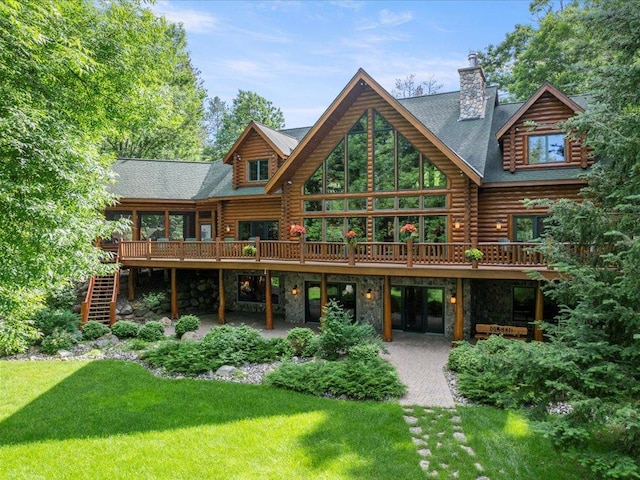 rear view of property with a yard, a deck, and a patio area