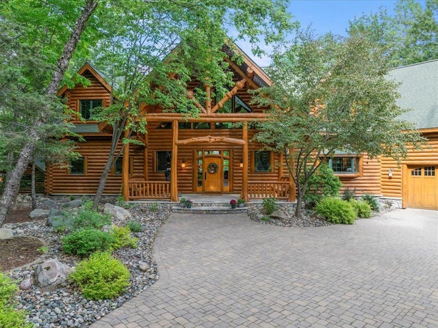 cabin featuring a garage and covered porch