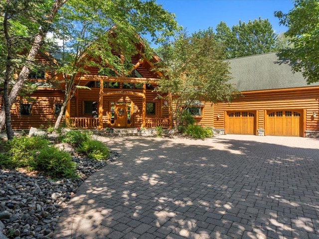 log-style house with a porch and a garage