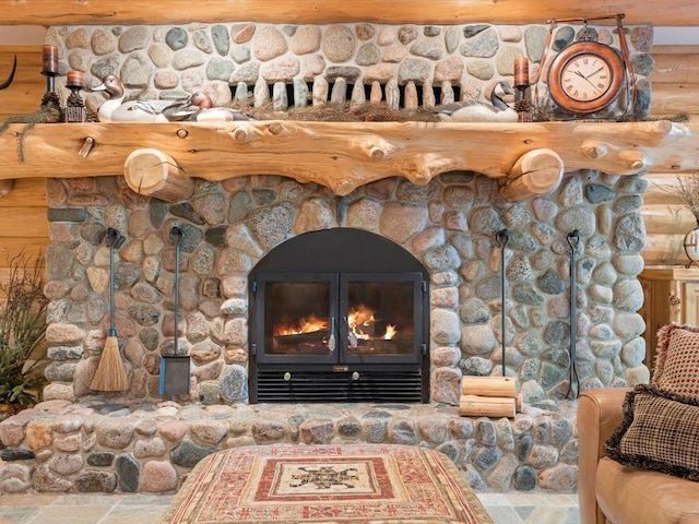 details featuring log walls and a stone fireplace