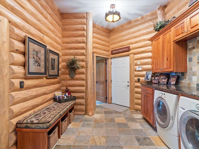 washroom with cabinets, washing machine and dryer, and log walls