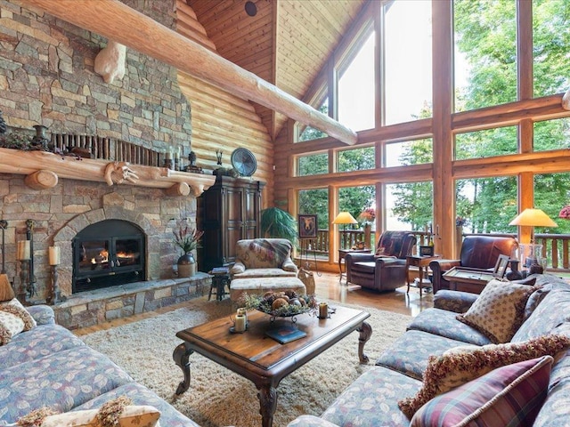 living room featuring hardwood / wood-style flooring, a fireplace, rustic walls, and high vaulted ceiling