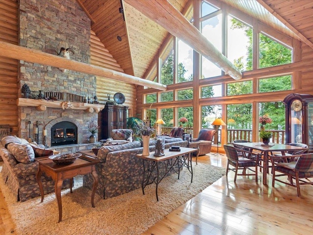 living room featuring a stone fireplace, rustic walls, high vaulted ceiling, and light wood-type flooring