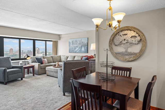 dining room with an inviting chandelier, a textured ceiling, and carpet floors