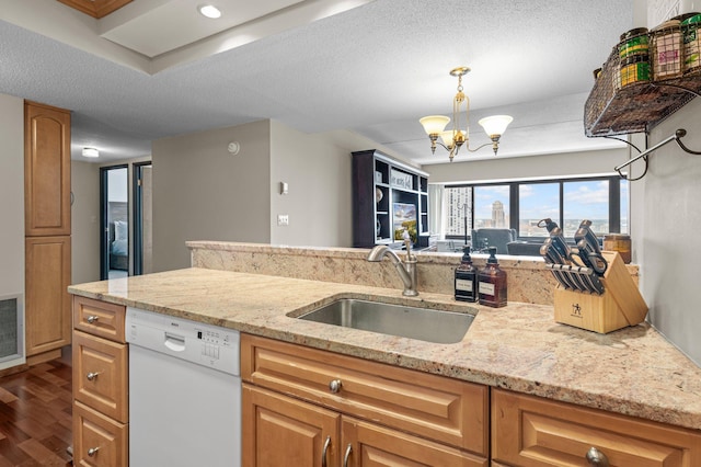 kitchen with white dishwasher, sink, wood-type flooring, a textured ceiling, and an inviting chandelier