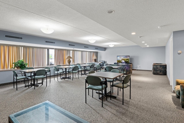 dining area featuring a textured ceiling, visible vents, and baseboards