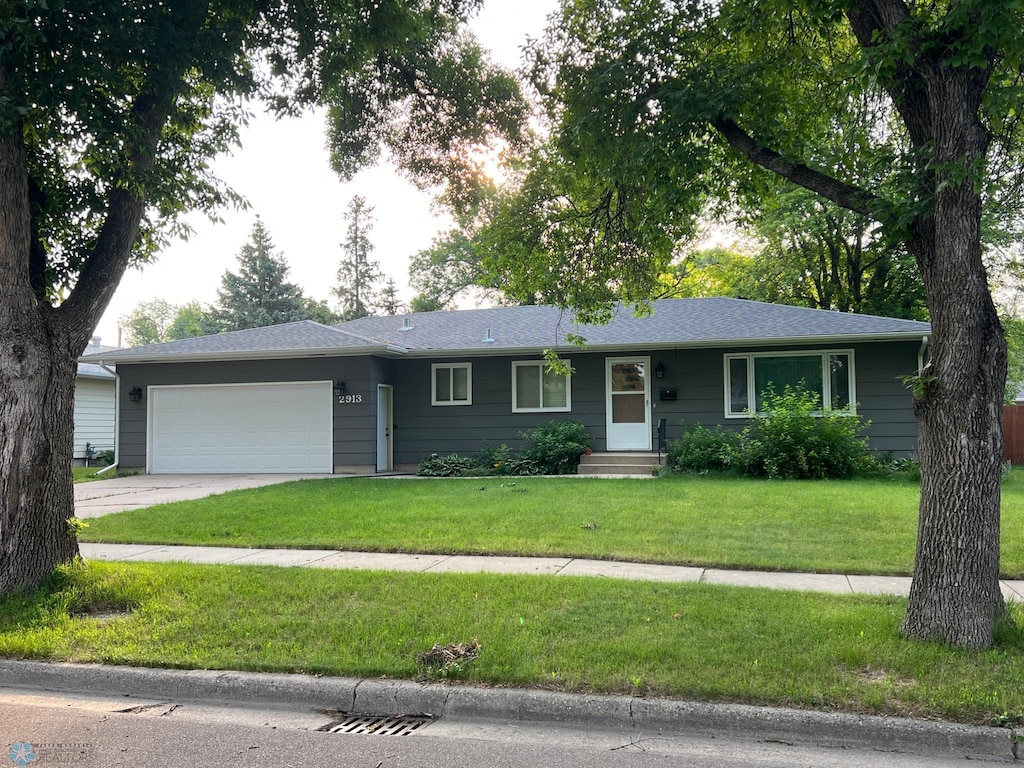 single story home with a garage and a front lawn