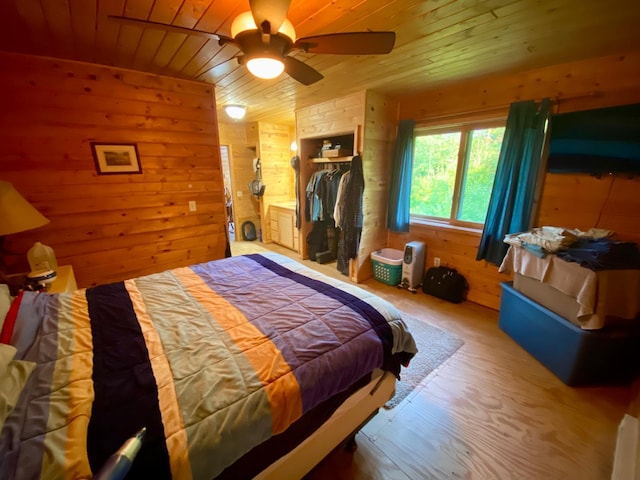 bedroom with wood ceiling, wood walls, ceiling fan, and wood-type flooring