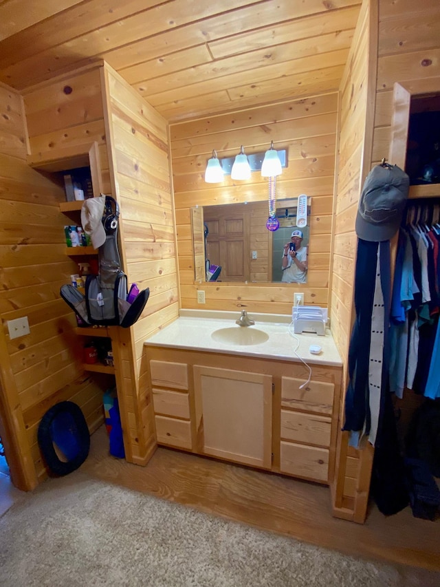 bathroom featuring vanity and wooden walls