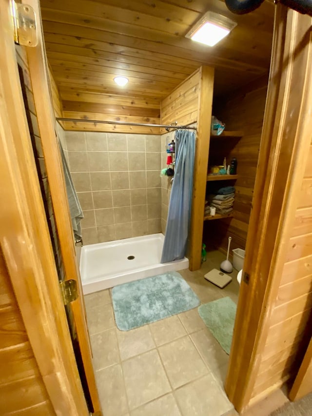 bathroom with wood walls, walk in shower, tile patterned floors, and wood ceiling