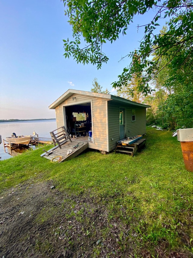 back of property with a water view and a yard