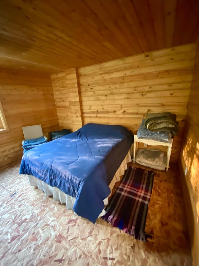 bedroom with wooden ceiling and wooden walls