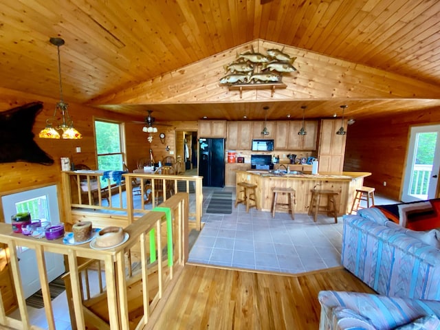 living room with an inviting chandelier, wood ceiling, sink, light wood-type flooring, and lofted ceiling