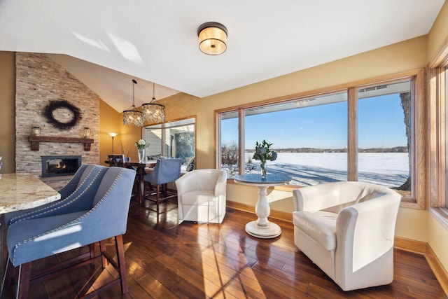 living room featuring a fireplace, vaulted ceiling, dark hardwood / wood-style floors, and a water view