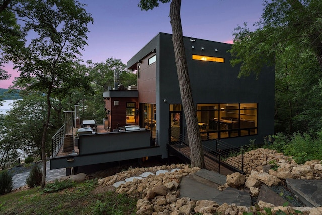 property exterior at dusk with a wooden deck