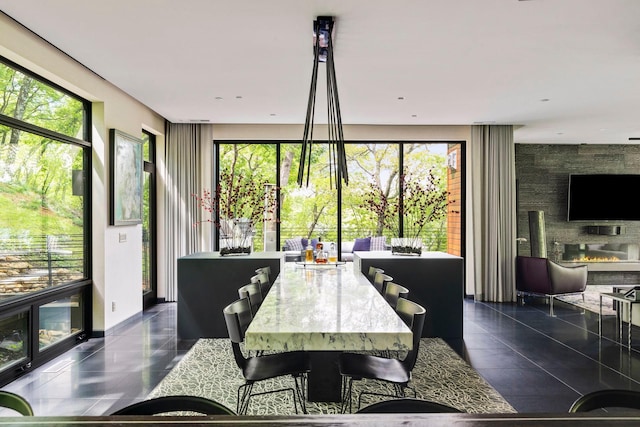 dining space with a large fireplace and dark tile patterned flooring