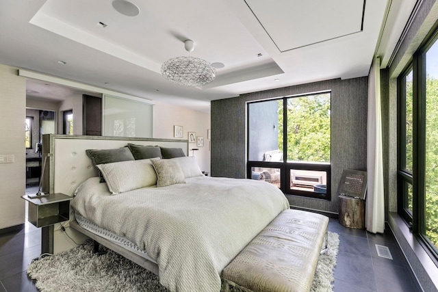 bedroom with a tray ceiling and an inviting chandelier