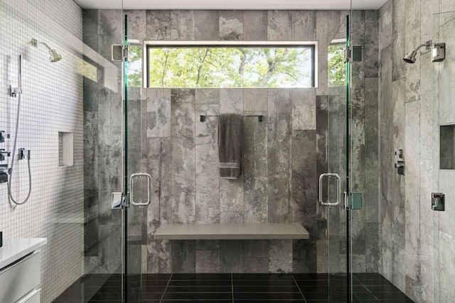 bathroom featuring a shower with door and a healthy amount of sunlight