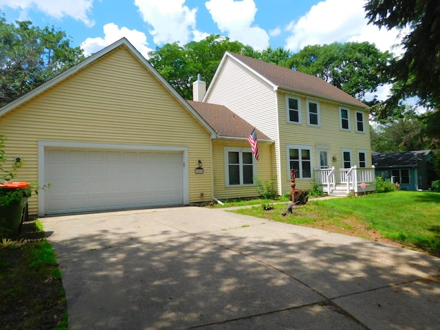 colonial house featuring a garage and a front lawn