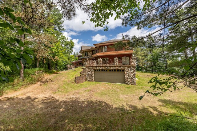 back of property with a garage, a yard, and a deck