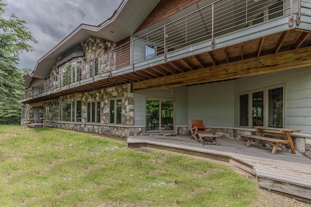 back of property with a wooden deck and a lawn