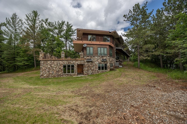 back of house with a yard and a balcony