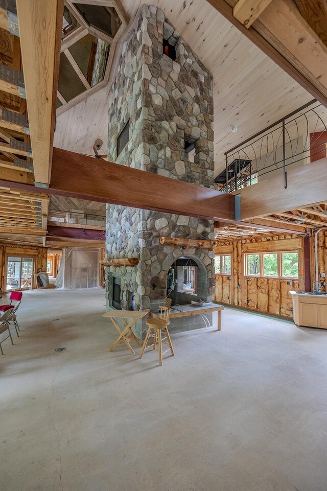 unfurnished living room with a fireplace, concrete floors, and a towering ceiling