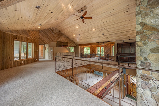 interior space with high vaulted ceiling, ceiling fan, wooden ceiling, and wood walls