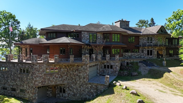 rear view of house featuring a garage and a balcony