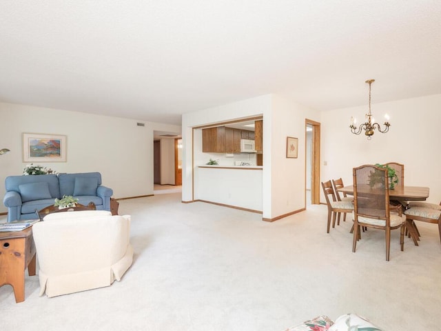 living area with an inviting chandelier, light colored carpet, and baseboards