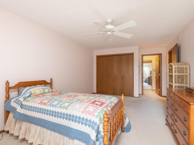 bedroom featuring a closet, light carpet, and a ceiling fan