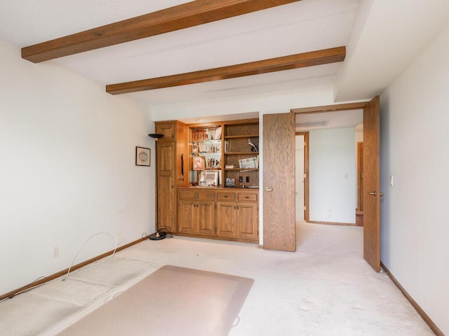 unfurnished living room with beamed ceiling and light colored carpet