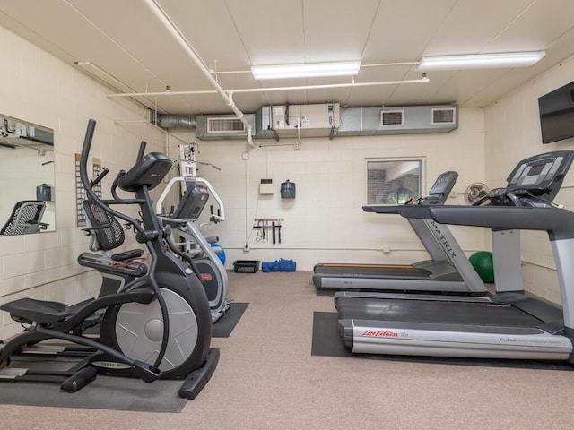 gym with visible vents and concrete block wall